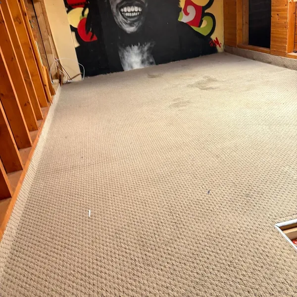 An attic room emptied, with a mural on the end wall