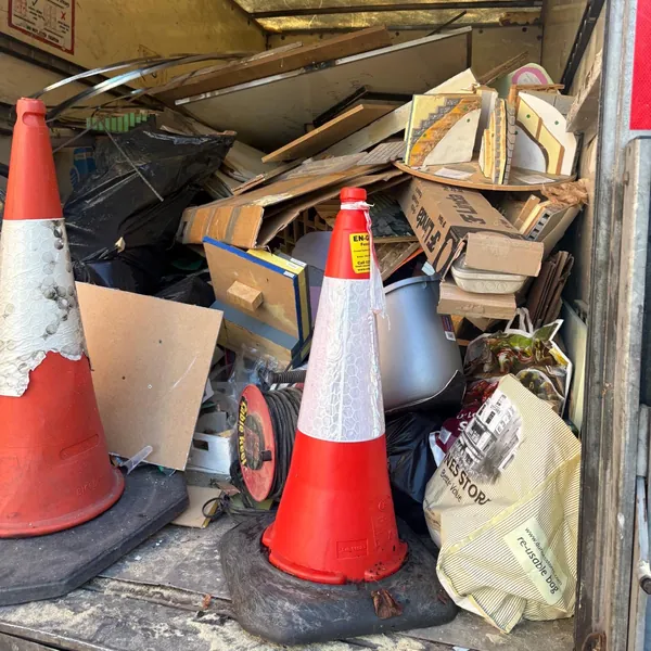 Two traffic cones, boxes and rubbish bags loaded in the back of the van