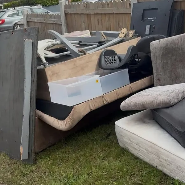 Furniture, mattresses and a television piled on a front lawn