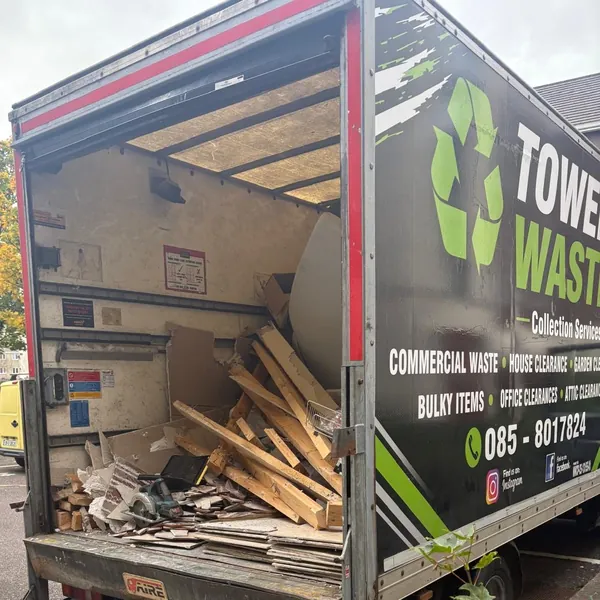The sign-written Tower Waste van with old timber loaded in the back