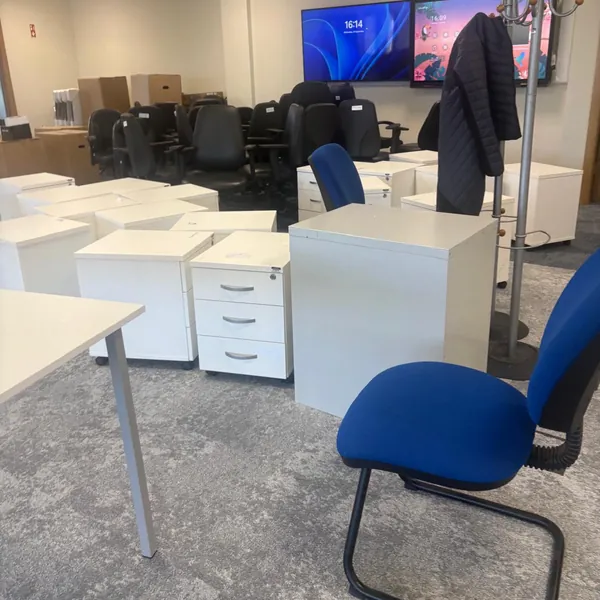 White drawer units and office chairs gathered up to go