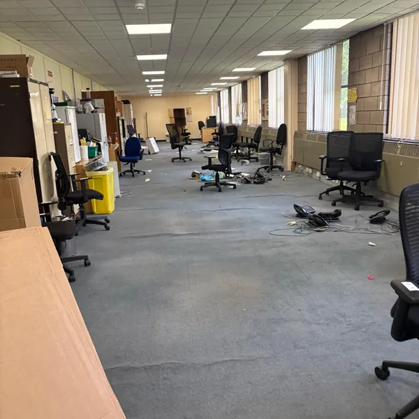 A long office floor with chairs and cables still to go