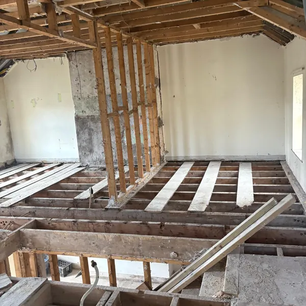 A room stripped back, ceiling down and floorboards up