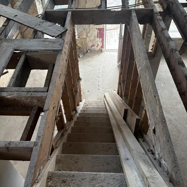 A stairwell between walls stripped back to the timber
