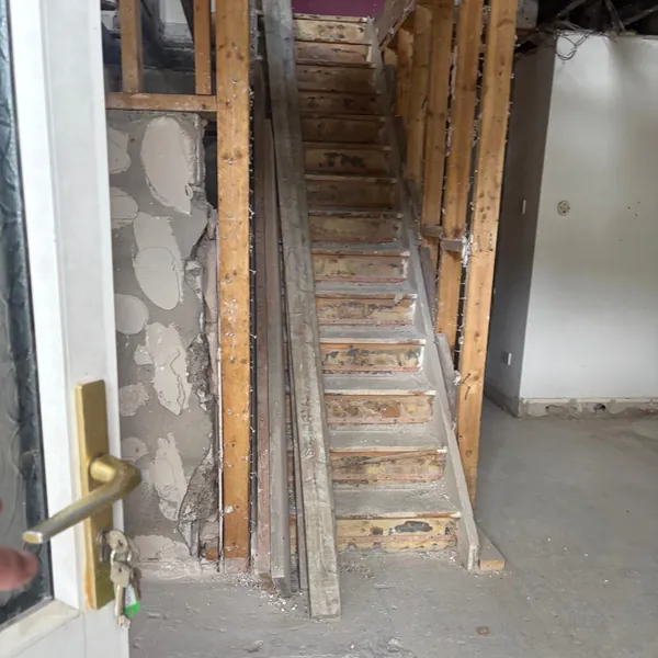 Stairs and stud walls with old timber stacked beside them